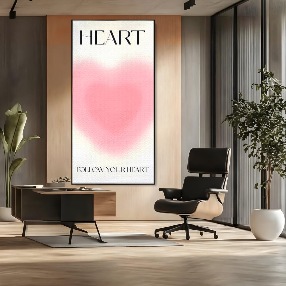 Tablou canvas cu tablou vertical cu inima roz blurata, in rama de aluminiu negru, pe perete intr-un birou